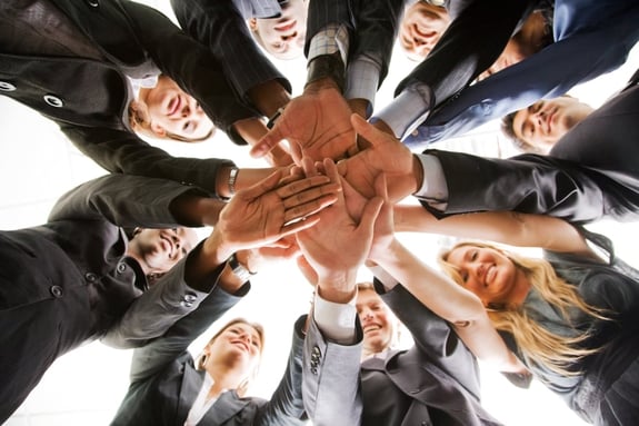 business people teamwork in an office with hands together - isolated